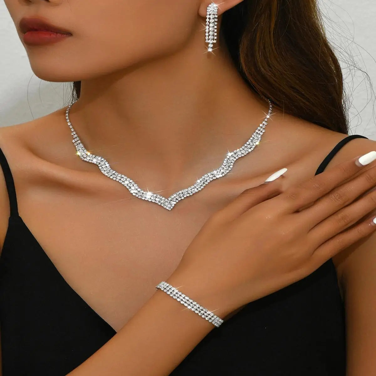 Jewelry set including necklace, earrings, and bracelet on a model against a neutral background